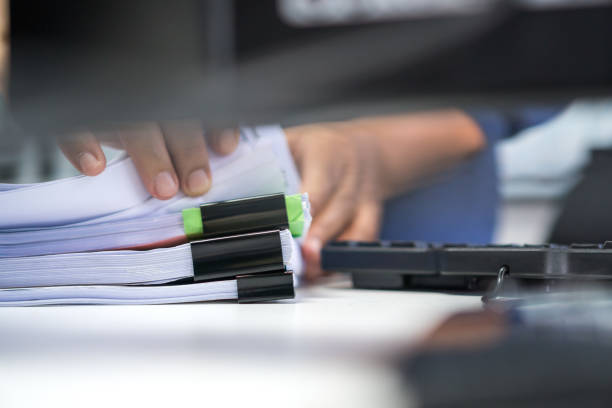 istock Paperwork files searching information business concept, Businessman hands typing keyboard computer, working in stacks of report papers and piles of unfinished documents achieves on office desk 1287362910