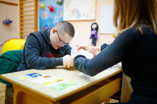 istock Female tutor helping a special needs teen boy 1287364064