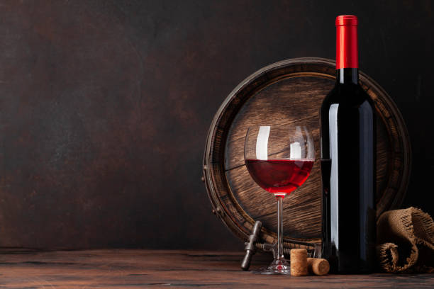 istock Wine bottle and old wooden barrel 1287366328