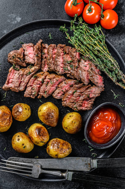 manzo di carne di marmo alla griglia bistecca con patate fritte. sfondo nero. vista dall'alto - steak strip steak prepared potato grilled foto e immagini stock