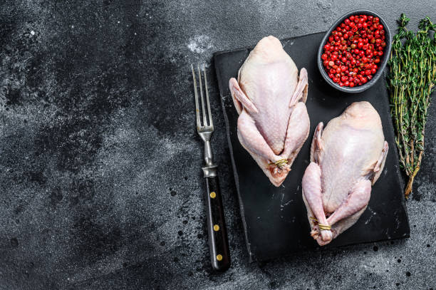 istock Farm eco friendly raw quails ready for cooking. Black background. Top view. Copy space 1287369112