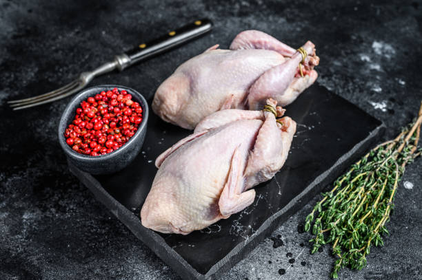 istock Farm eco friendly raw quails ready for cooking. Black background. Top view 1287369124
