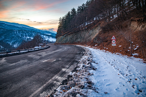 asphalt road and snow in rock background