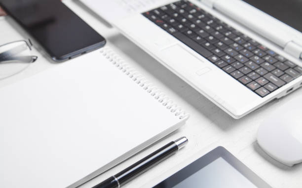 istock White laptop and business objects on the white desk. 1287372019