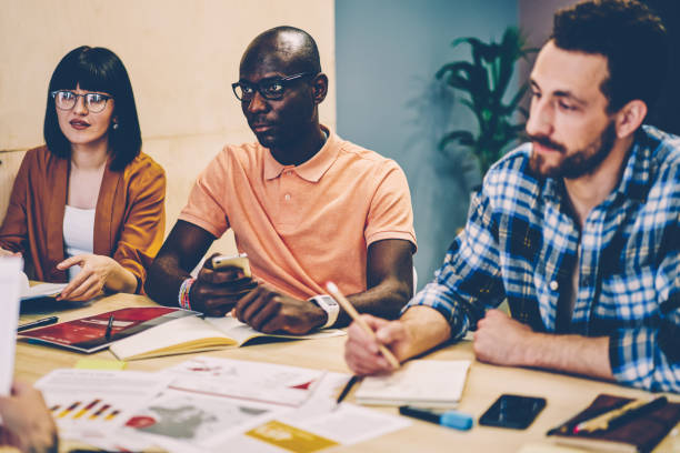 istock Multicultural group of young people dressed in smart casual wear collaborating on discussion of creating ideas having brainstorming meeting in modern coworking.Diverse employees cooperating on project 1287374493