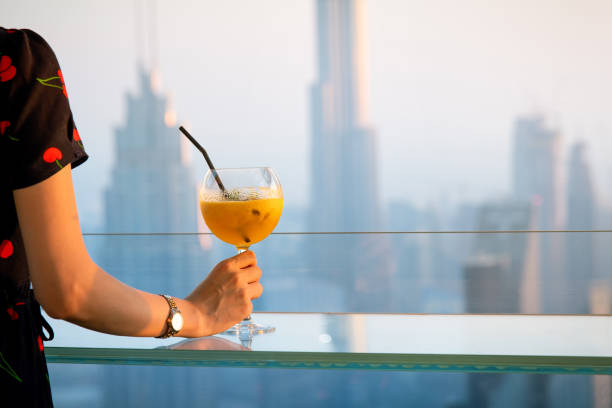 음료를 마시고 두바이 시내 전망을 즐기는 여성 - dubai united arab emirates hotel luxury 뉴스 사진 이미지