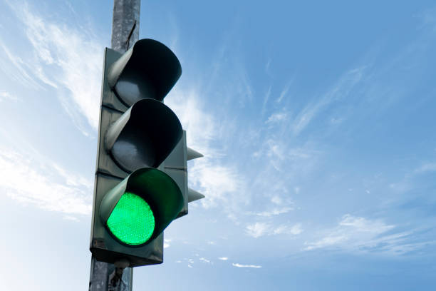 istock Traffic light in green color, with a blue sky and cloud in the background. 1287375280