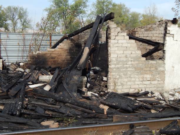 istock Burnt building after a fire. Abandoned burnt-out building. Black coals and burnt boards. 1287375456