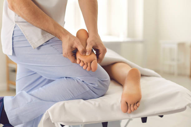 masseur mâle professionnel faisant le massage de pied pour la jeune femme dans le centre moderne de santé - massagist photos et images de collection