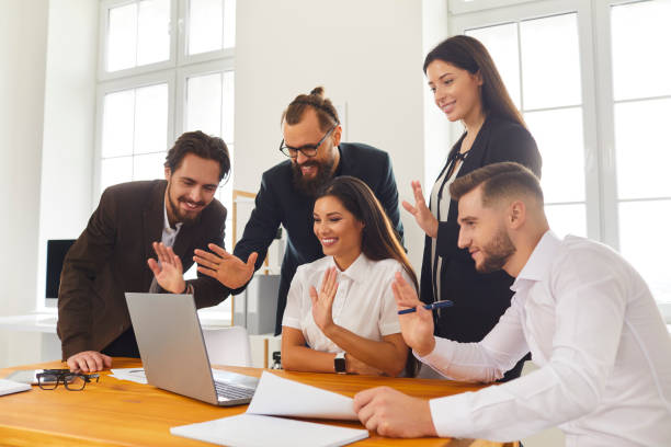 istock Happy company workers waving hands at laptop screen greeting boss during video call 1287377023
