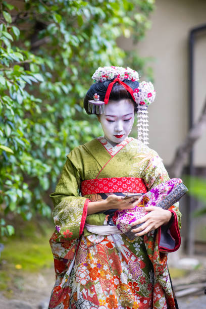istock Maiko (Geisha in training) using smart phone in Gion district in Kyoto 1287377743