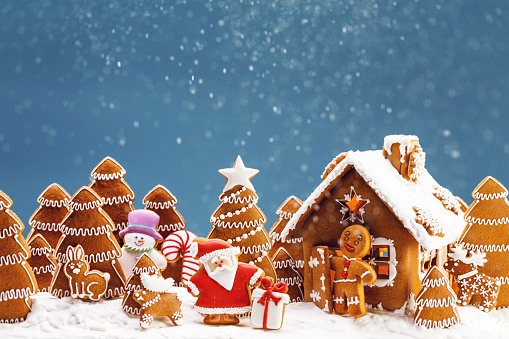 Gingerbread house christmas fir trees Santa Claus and gift cookies winter holiday celebration concept