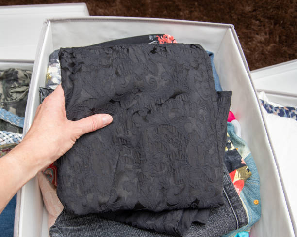 istock Women's hands folds clothes, things in storage boxes. Clothes storage concept 1287378613