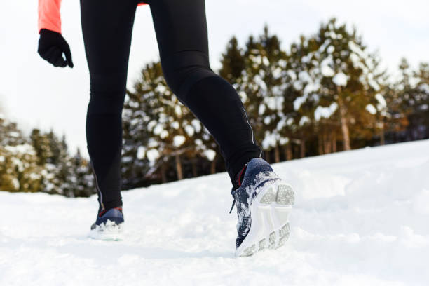 istock Crop sportswoman running on snow 1287378718