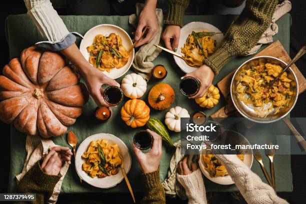 Friends Celebrating Thanksgiving Day With Wine And Squash Pasta Stock Photo - Download Image Now