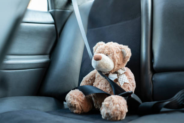 istock small teddy bear protected with safety belt in car, vehicle accident security 1287383347