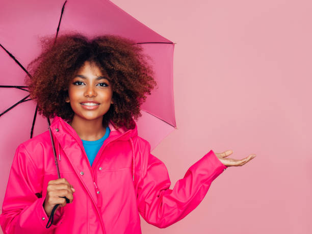 istock Afro girl with pink umbrella 1287384059