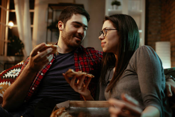 istock Happy couple eating pizza at home. 1287384207