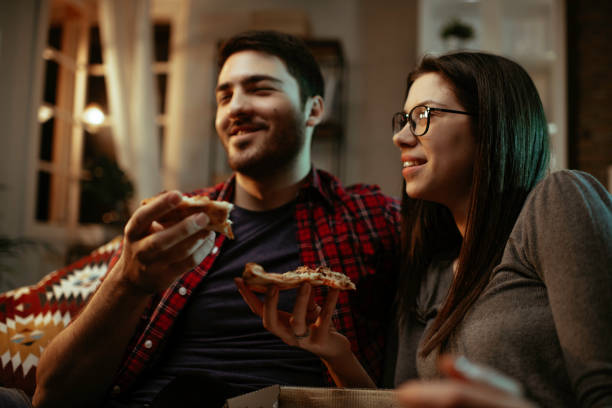istock Happy couple eating pizza at home. 1287384430