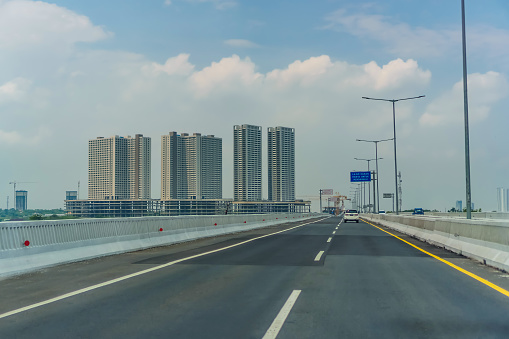 Jakarta, Indonesia - (11/21/20): Wide view of Cikampek toll road with few cars and some buildings around during the day.