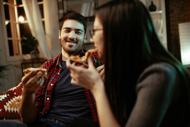 istock Happy couple eating pizza at home. 1287385661