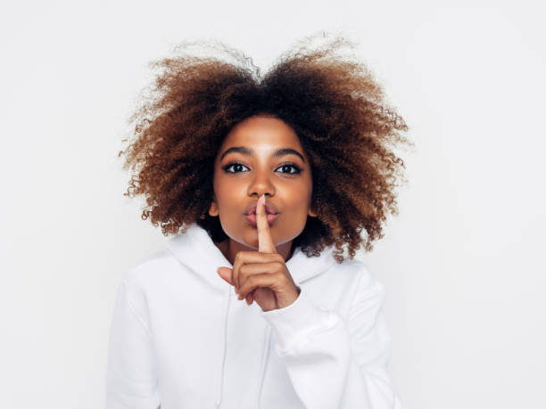 beautiful afro woman showing to be quiet - finger on lips imagens e fotografias de stock