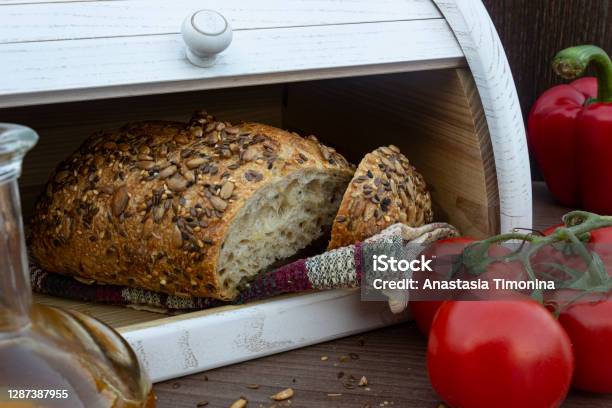 Closeup White Wooden Bread Box With Homemade Bread Inside Breadbox With Cutted Bread Tomatoes Olive Oil In Glass Bottle And Red Bell Peppers On The Dark Wooden Background Stock Photo - Download Image Now