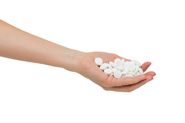 istock Woman's hand with a bunch of large white pills 1287390605