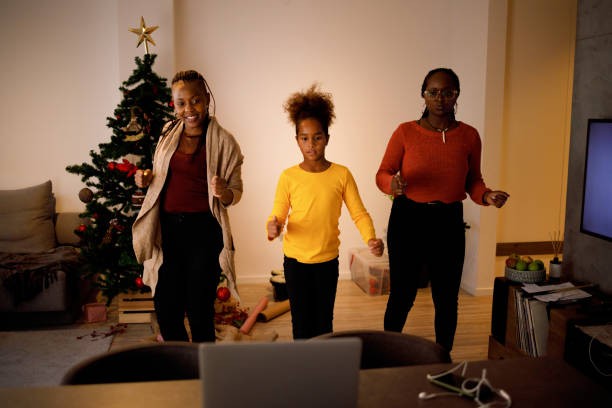 Tap tok Three female members of an African American family have lots of fun dancing Tik Tok routines on Christmas day. moving image stock pictures, royalty-free photos & images