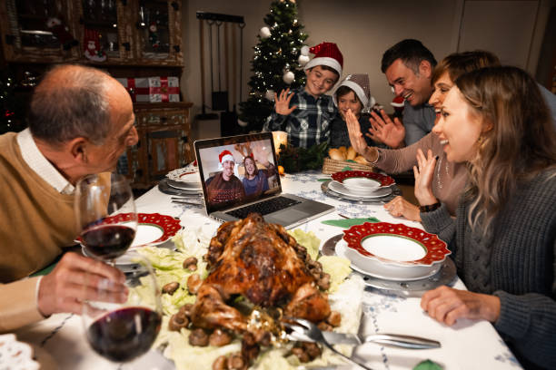 A couple on a screen and some relatives celebrating Christmas using a video call. A couple on a screen and some relatives celebrating Christmas using a video call. People greeting their family and friends on Christmas eve online. Social distancing, self isolation quarantine. thanksgiving holiday covid stock pictures, royalty-free photos & images