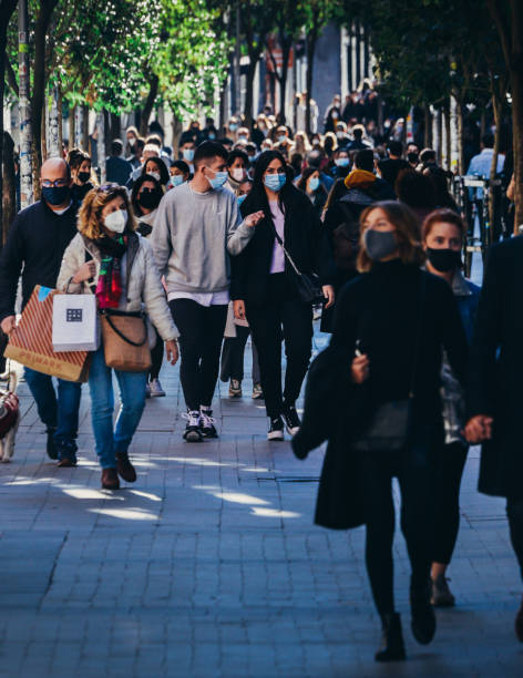 Crowded pedestrian street in Madrid, Spain Madrid, Spain - November 21, 2020: Crowded pedestrian street in Madrid, Spain. People wear obligatory face covering during the Covid-19 pandemic. Captured at 300mm. Bokeh selective focus covid crowd stock pictures, royalty-free photos & images