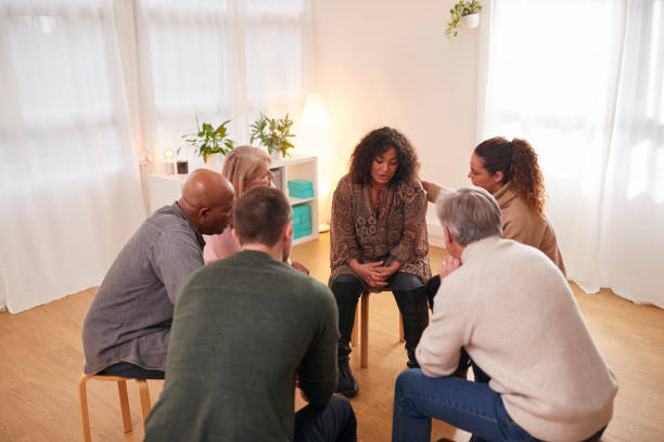 istock Group Consoling Woman Speaking At Support Group Meeting For Mental Health Or Dependency Issues 1287394467