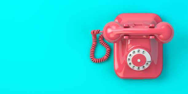 istock Pink vintage rotary telephone on mint green background. 1287394805