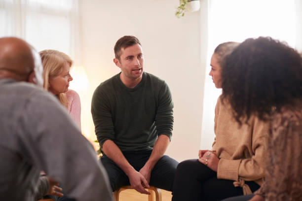 istock Man Speaking At Support Group Meeting For Mental Health Or Dependency Issues In Community Space 1287395261