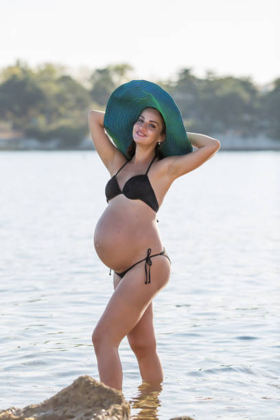 donna incinta al mare - women wading sun hat summer foto e immagini stock