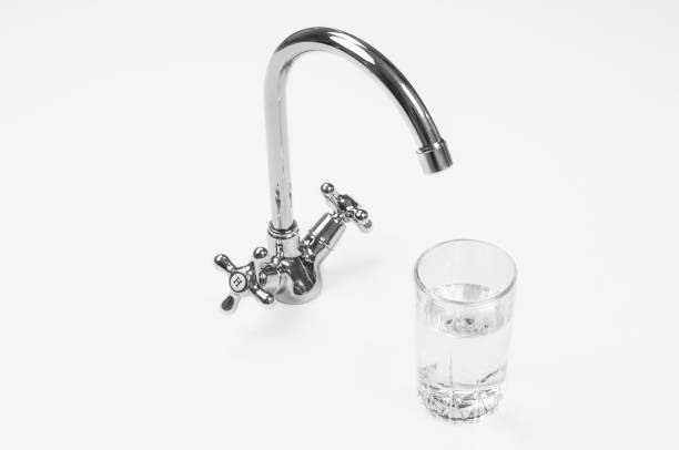 istock Faucet and water glass on white background 1287396463