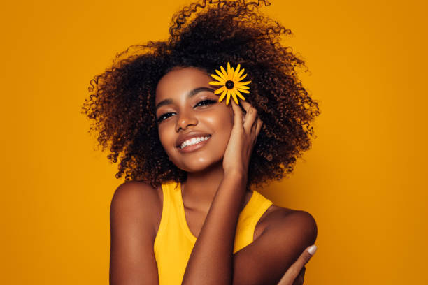 istock Beautiful afro woman with a flower 1287396704