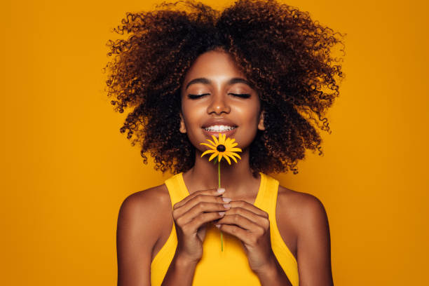 花を持つ美しいアフロの女性 - nature curly hair smiling human face ストックフォトと画像