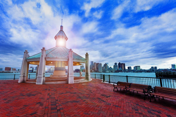 East Boston Piers Park Gazebo with lighthouse view East Boston Piers Park Gazebo with lighthouse light in the evening over downtown panorama view east boston stock pictures, royalty-free photos & images