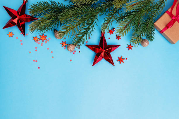 istock Spruce branch and Red Christmas decor on blue background 1287398698