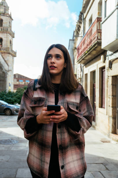 istock Young woman walking through town using a mobile 1287398875