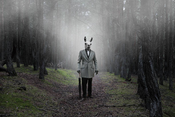 Mystical picture of a strange creature with guanaco head in a mysterious forest Mystical picture of a strange creature with a human body and a guanaco head in a mysterious forest covered with fog animal head man stock pictures, royalty-free photos & images