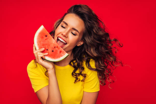 istock Smiling young woman holding watermelon 1287399358