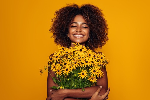 Beautiful afro woman with bunch of flowers