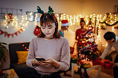 クリスマスと新年の夜に自宅で日本の友人、ネットワーク上で共有するためにスマートフォンを使用して女性