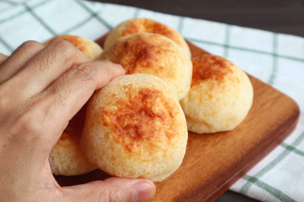 Closeup hand Holding a Fresh Baked Homemade Brazilian Cheese Bread or Pao de Queijo