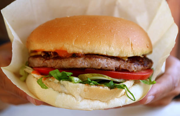 istock Closeup a delectable big hamburger in wrapping paper 1287403112