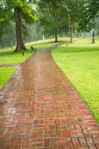Winding park pathway surrounded by trees and greenery on calm spring day in New Jersey.