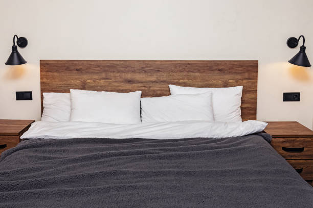 istock Modern minimalist bedroom interior. Bed with wooden headboard white pillows 1287404880