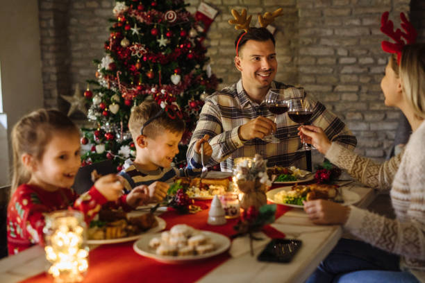 istock Parents toasting with wine while having a Christmas dinner party with their children in dining room 1287405079